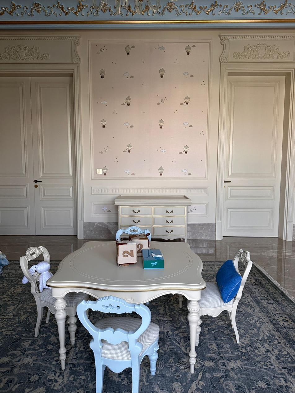 Bespoke chest of drawers with gold-toned handles, alongside a children&rsquo;s dining set on a rug