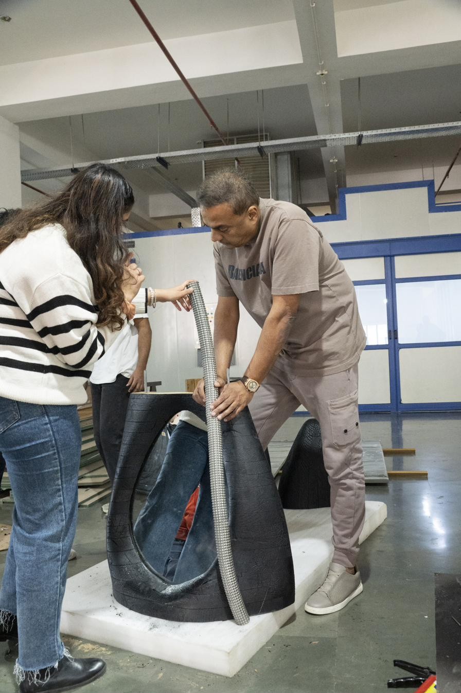 Two people working with a charred sculptural piece at the Popcorn Atelier workshop