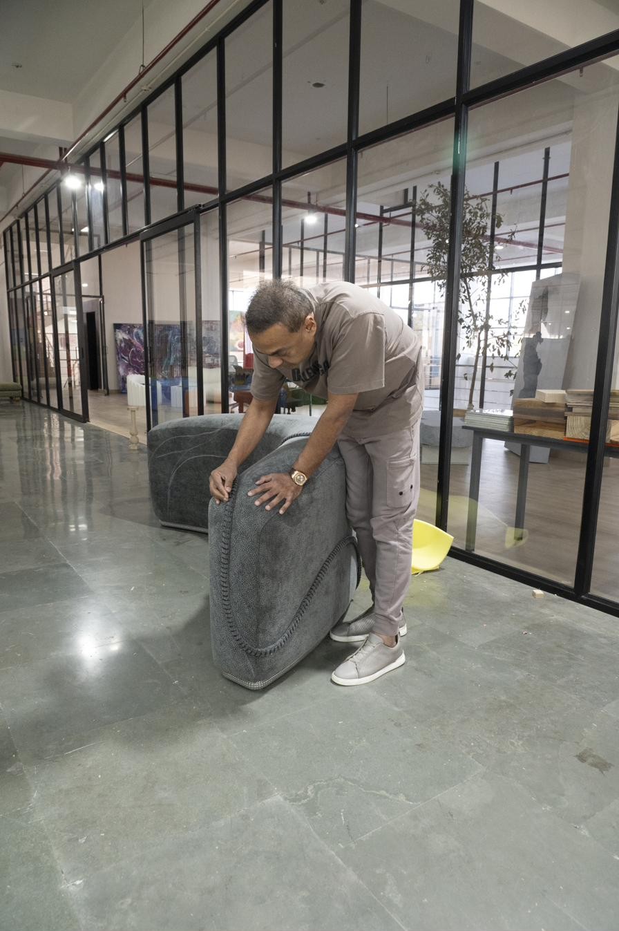 Sculptural upholstered lounge piece being positioned in a showroom space